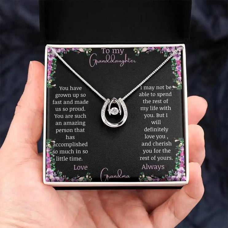 Lucky In Love Necklace with a white gold charm with a to granddaughter from grandma greeting card in a two-tone box in a models hand
