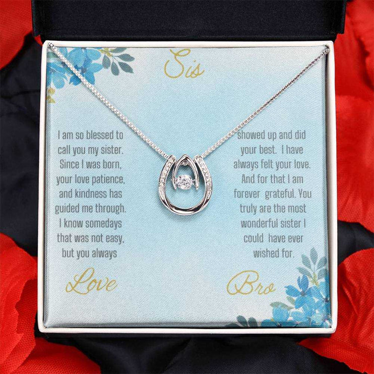 Lucky In Love Necklace with a white gold charm on a To Sis From Bro greeting card in a two-tone box up close