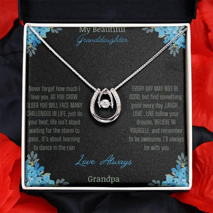 Lucky In Love Necklace with a white gold charm on a to granddaughter from grandpa greeting card on a black table with red roses