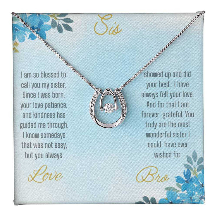 Lucky In Love Necklace with a white gold charm on a To Sis From Bro greeting card inside a two-tone box up close