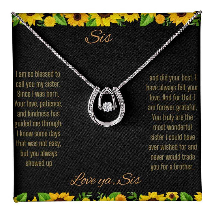 Lucky In Love Necklace with a white gold charm on a To Sis From Sis greeting card up close view