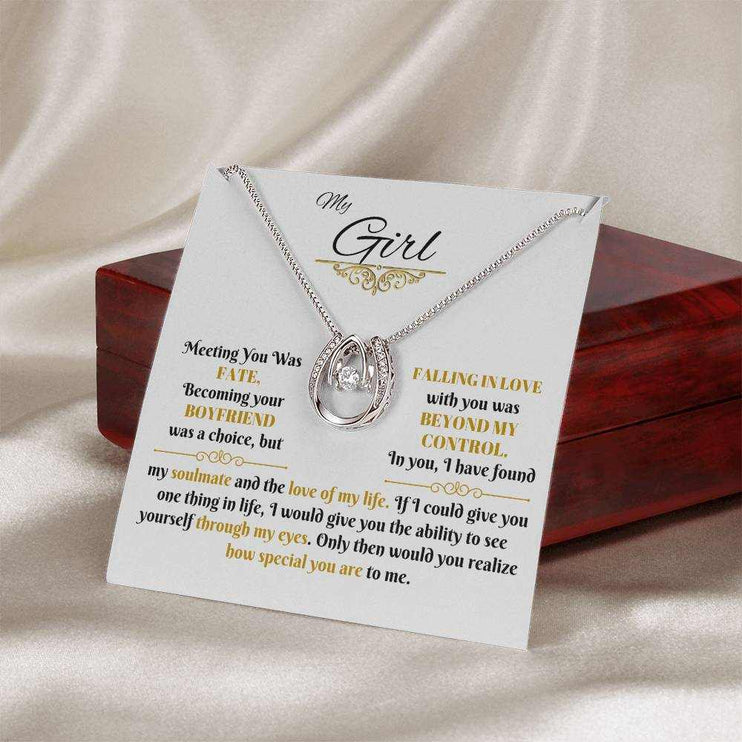 lucky in love necklace on a message card outside of a closed luxury box