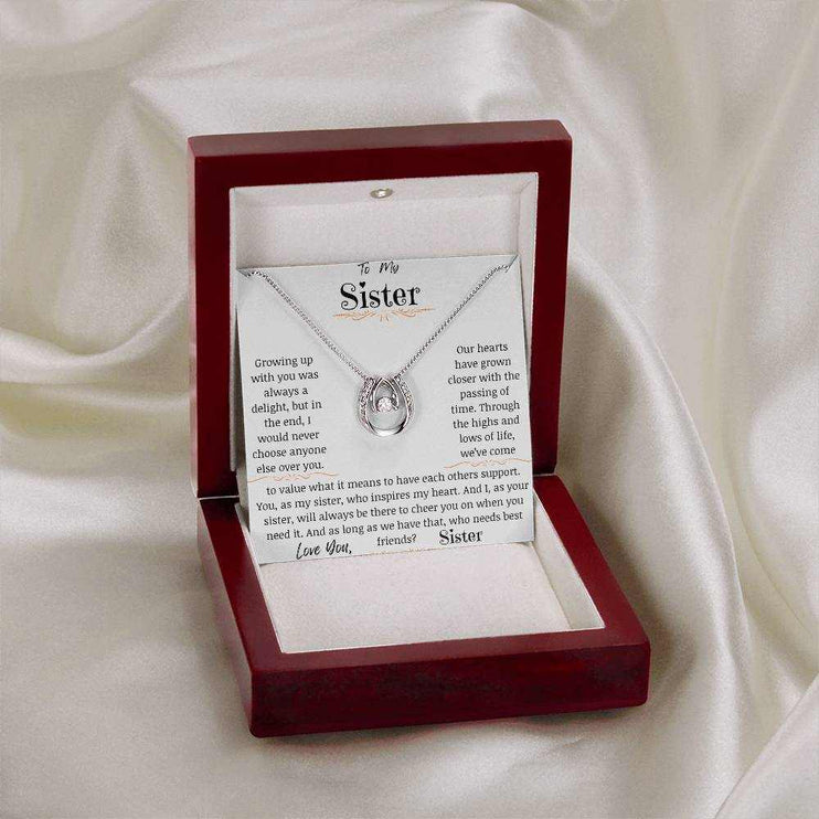 a white gold lucky in love necklace in a mahogany box on a white cloth