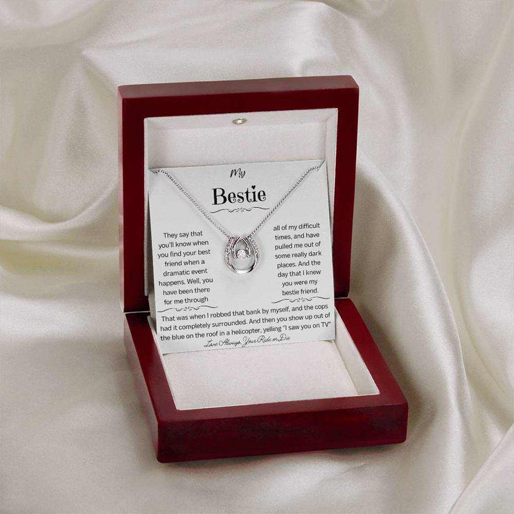 a white gold lucky in love necklace in a mahogany box on a white cloth