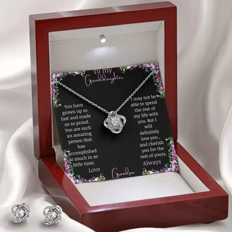 Love Knot Necklace Love Knot Earring Set with a white gold pendant and a to granddaughter from grandma greeting card in a mahogany box angled to the right with earrings on left side of box