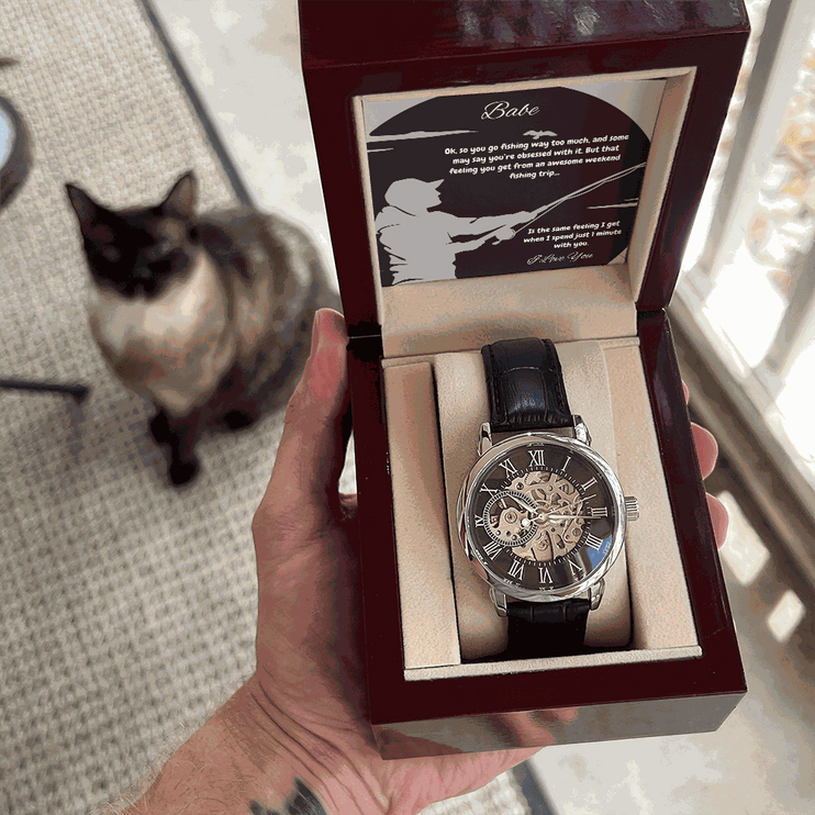 openwork watch in a mahogany box in a model's hand with a cat