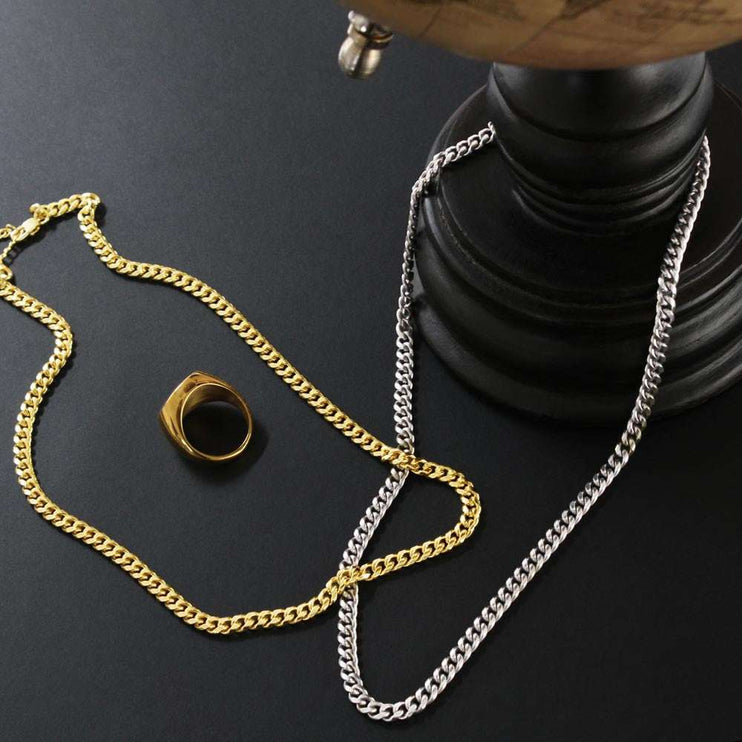 yellow gold and stainless-steel Cuban link chain on a black table