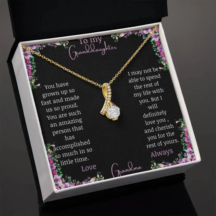 Alluring Beauty Necklace with a yellow gold charm with a to granddaughter from grandma greeting card in a two-tone box angled to right side