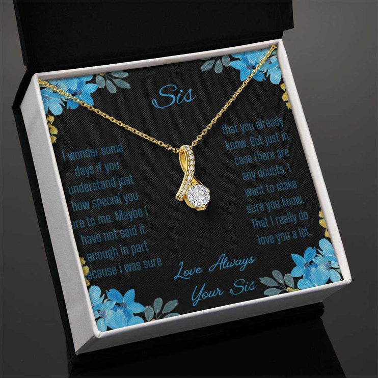Alluring Beauty Necklace with a yellow gold variant on a to sis from sis greeting card inside a two-tone box angled slightly to the left with a close up view.