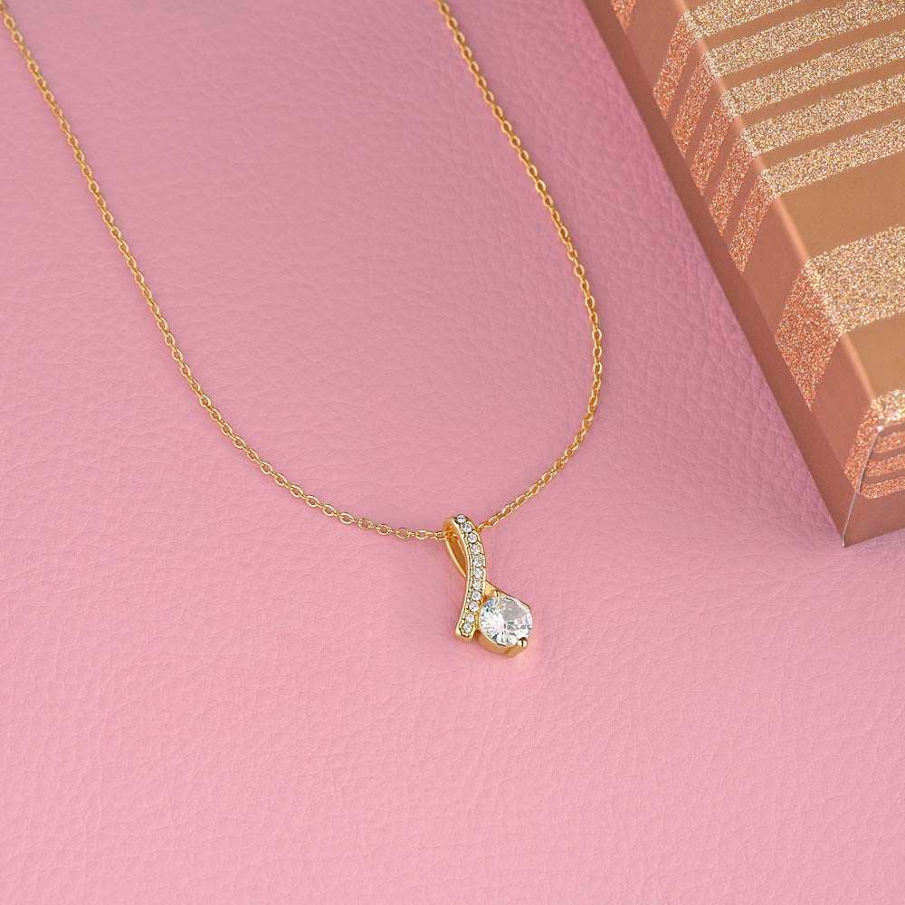 yellow gold alluring beauty necklace on a pink table