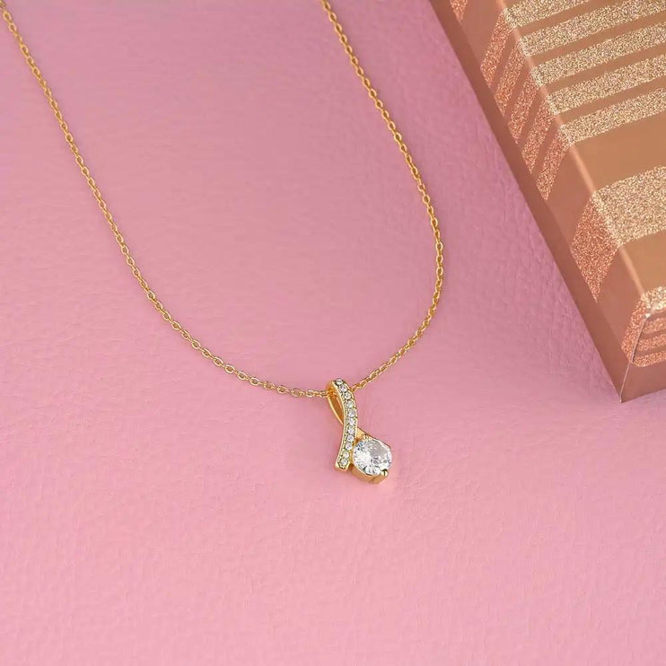 yellow gold alluring beauty necklace on pink table