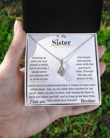 a white gold alluring beauty necklace in a models hand.