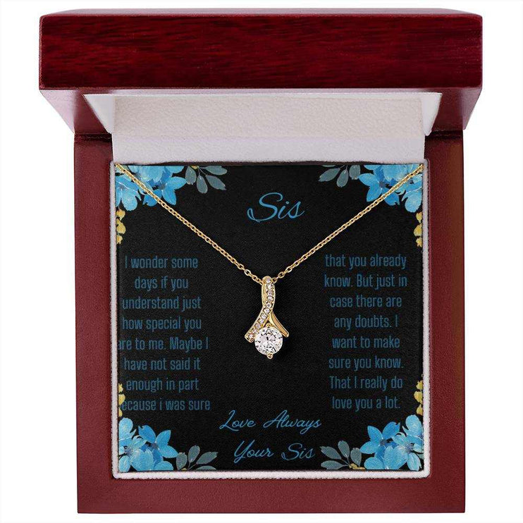 Alluring Beauty Necklace with a yellow gold variant on a to sis from sis greeting card inside a mahogany box with a close up view.