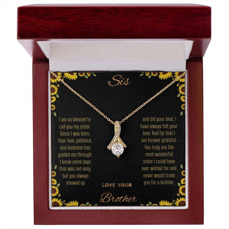 Alluring Beauty Necklace with a yellow gold variant on a To Sis from Brother greeting card inside a mahogany close up view