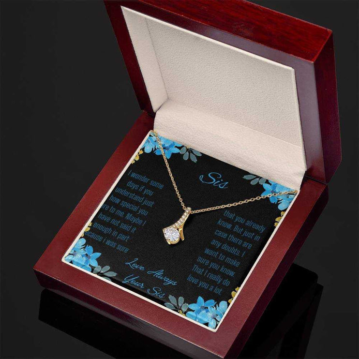 Alluring Beauty Necklace with a yellow gold variant on a to sis from sis greeting card inside a mahogany box angled slightly to the right with a close up view.