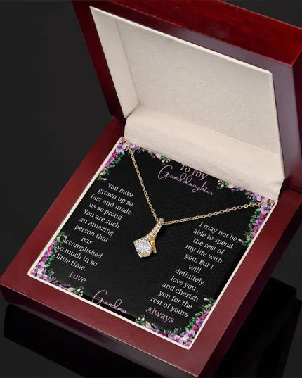 Alluring Beauty Necklace with a yellow gold charm with a to granddaughter from grandma greeting card up close in a mahogany box angled to the right side