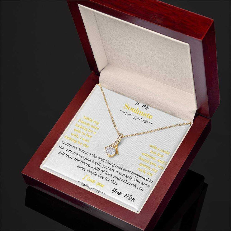 A yellow gold alluring beauty necklace in a mahogany box on a angle.