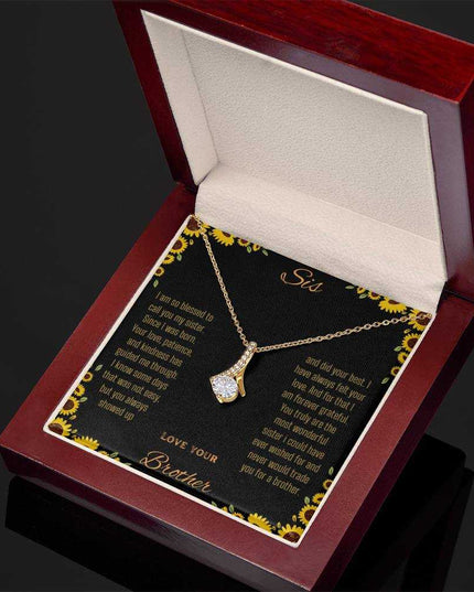 Alluring Beauty Necklace with a yellow gold variant on a To Sis from Brother greeting card inside a mahogany box angled slightly to the right close up view