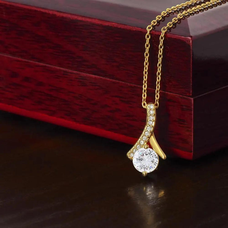 yellow gold alluring beauty necklace on top of a mahogany box