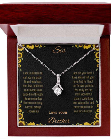 Alluring Beauty Necklace with a white gold variant on a To Sis from Brother greeting card inside a mahogany close up view