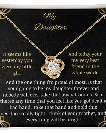 Love Knot Necklace with a yellow gold charm in a two-tone box with a to daughter from mom greeting card close up