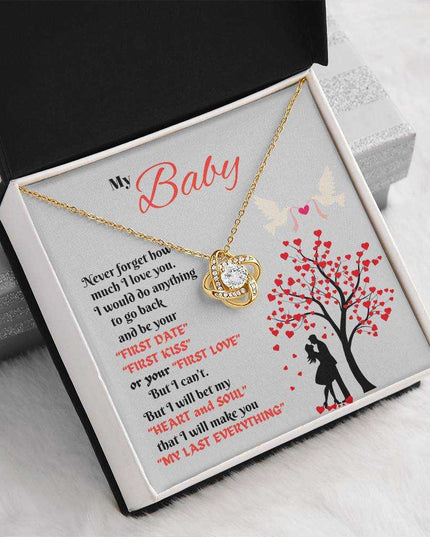 gold love knot necklace in soft box angled left tilted up