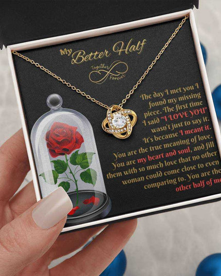 18k gold love knot necklace in soft box in model's hands