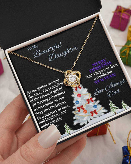 yellow gold love knot necklace in soft box in model's hand