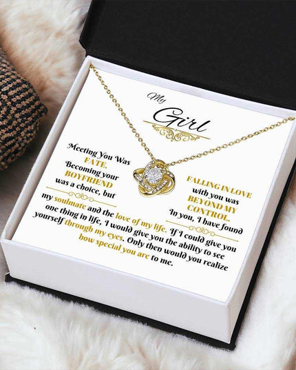 yellow gold love knot necklace in a soft box angled right