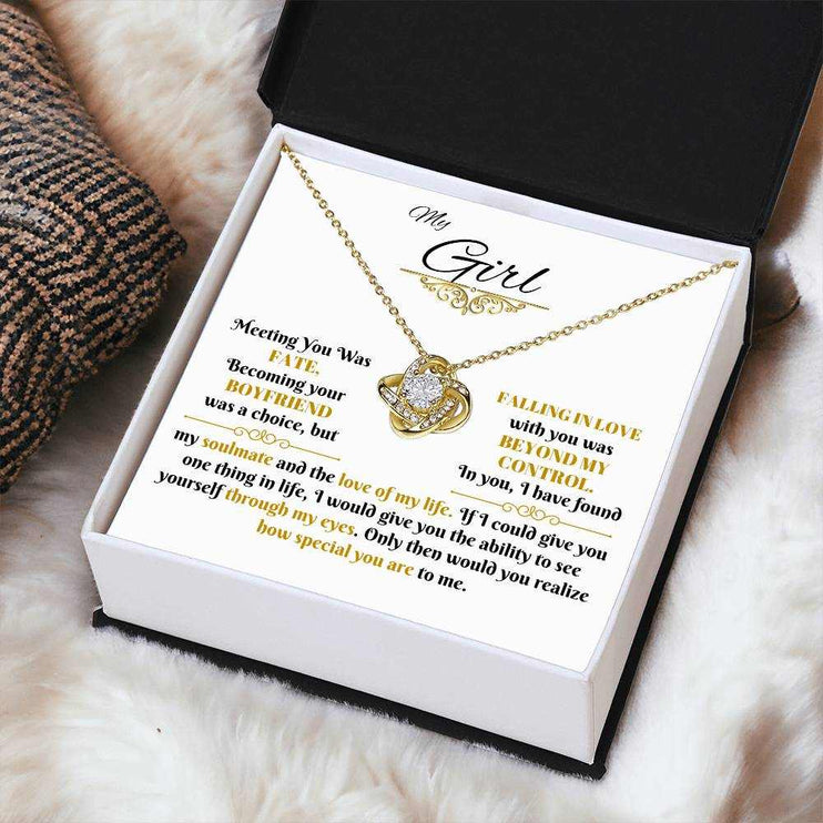 yellow gold love knot necklace in a soft box angled right