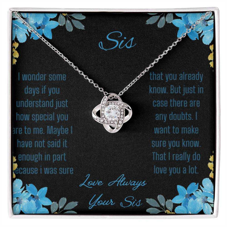 Love Knot Necklace with a white gold variant on a To Sis from Sis greeting card close up view
