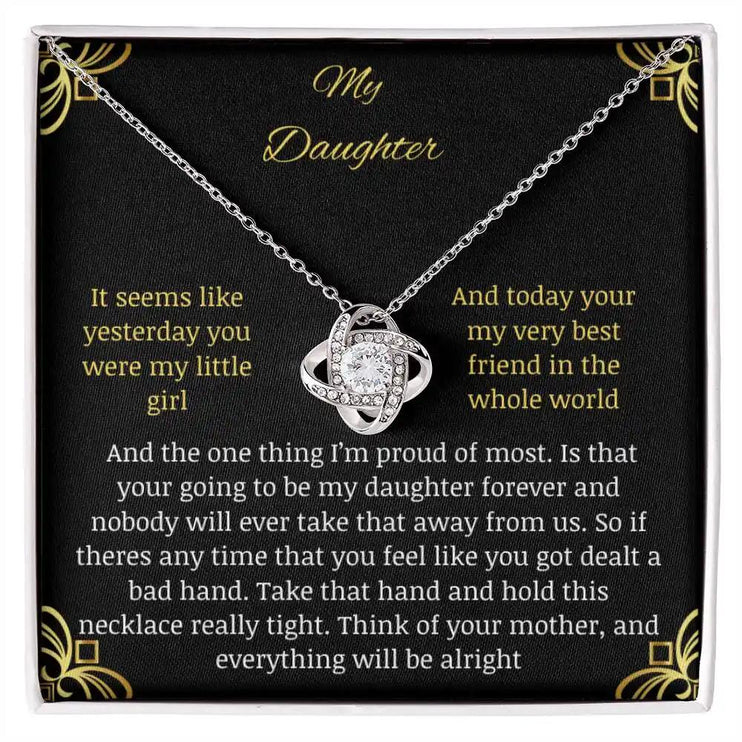 Love Knot Necklace close up with a white gold charm in a two-tone box with a to daughter from mom greeting card 