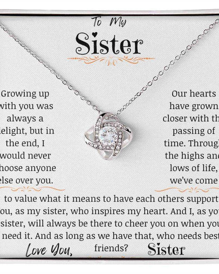 a white gold love knot necklace up close.