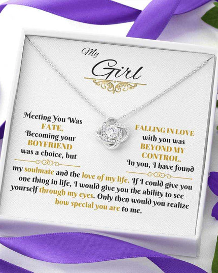 white gold love knot necklace in a soft box up close angled right