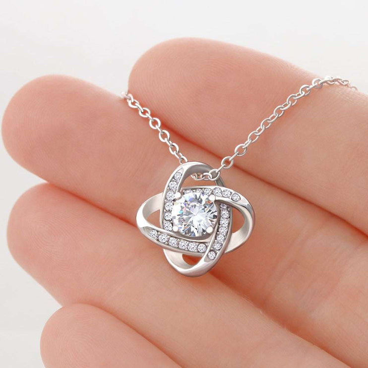 white gold love knot necklace in model's hand