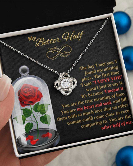 14k white gold love knot necklace in soft box in model's hand