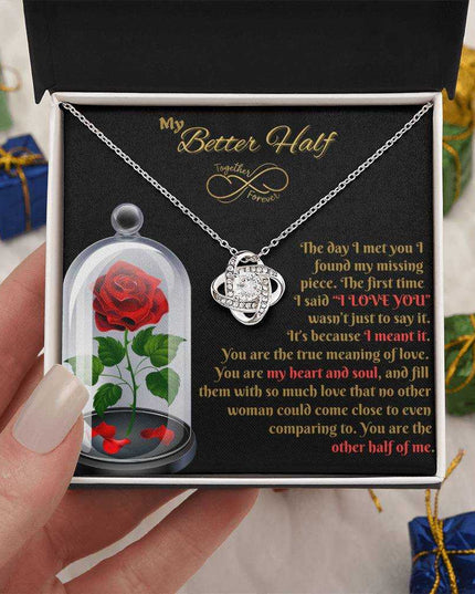 14k white gold love knot necklace in soft box in model's hand