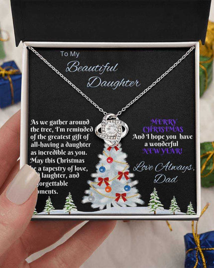 white gold love knot necklace in soft box in a model's hand birds eye 