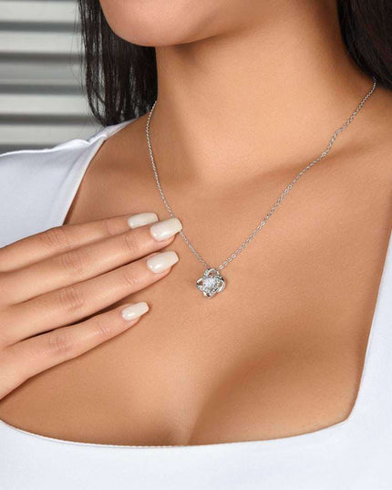 white gold love knot necklace on a model's neck