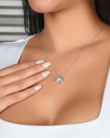 white gold love knot necklace on a model's neck