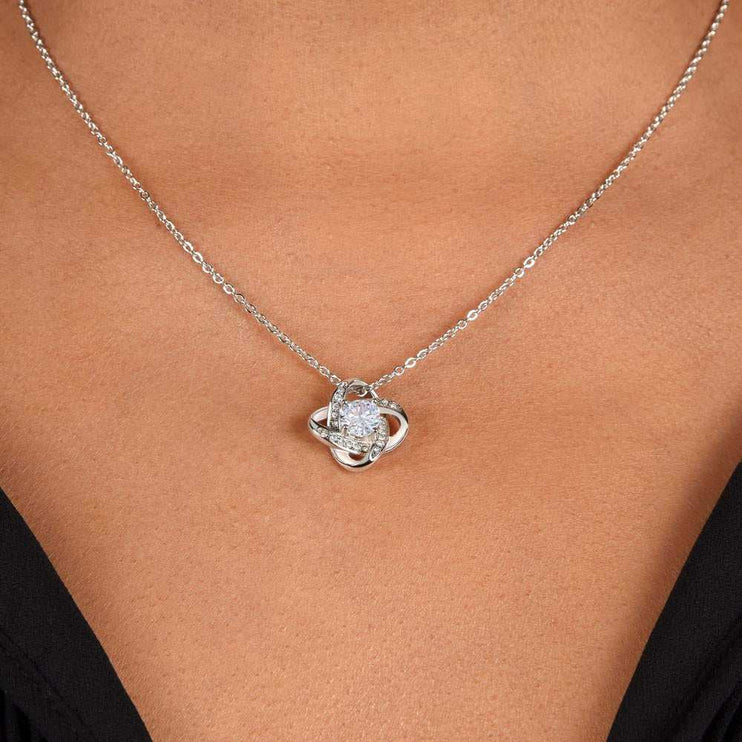 white gold love knot necklace on model's neck