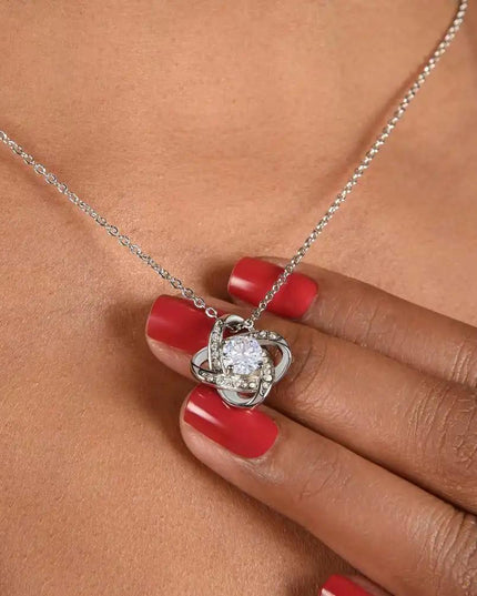white gold love knot necklace on a model's neck