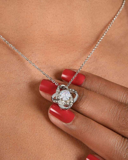 white gold love knot necklace on a model's neck