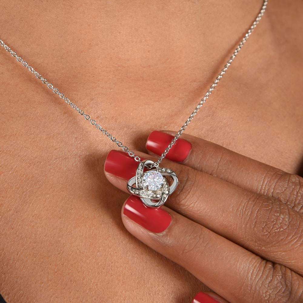 14k white gold love knot necklace on a model's neck