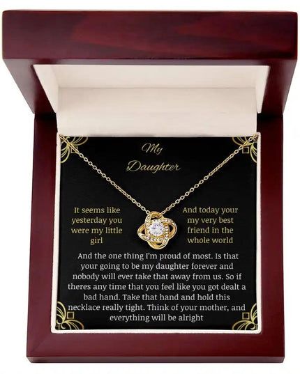 Love Knot Necklace with a yellow gold charm in a mahogany box with a to daughter from mom greeting card close up