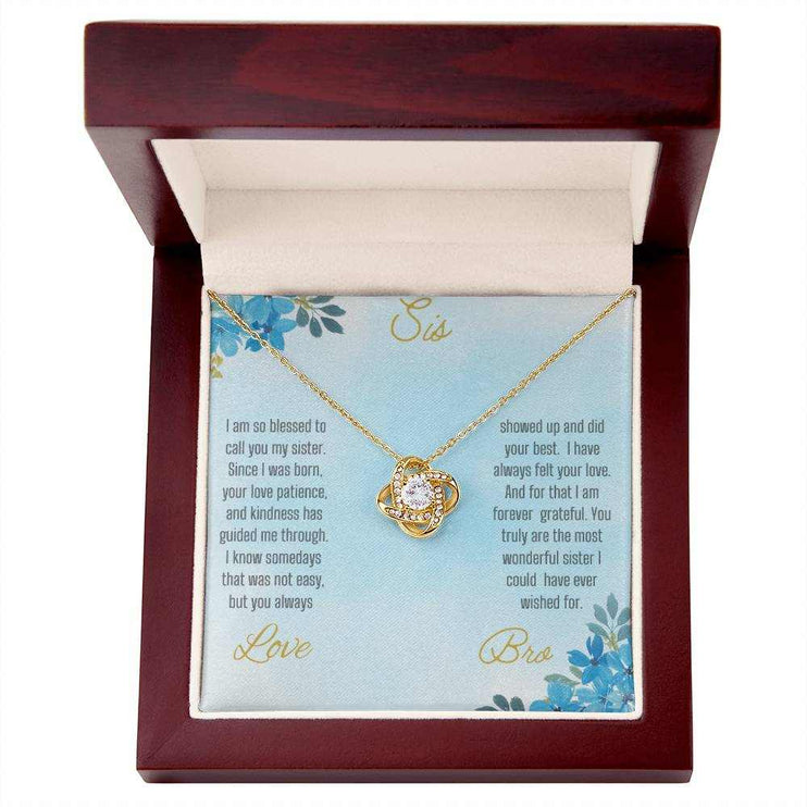 Love Knot Necklace with a yellow gold pendant on a To Sis from Bro greeting card inside of a mahogany box close view