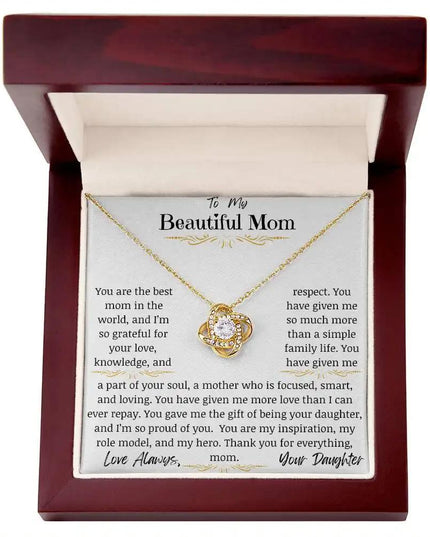 a yellow gold love knot necklace up close in a mahogany box