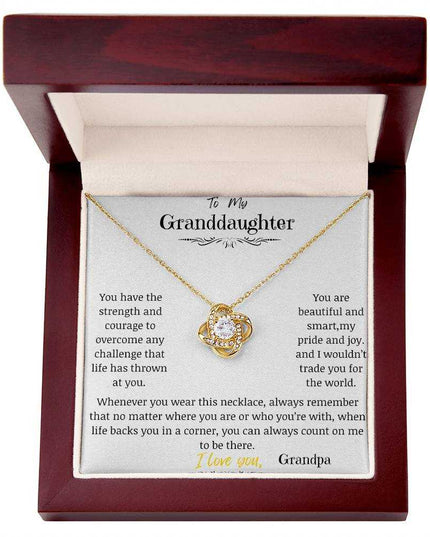 a yellow gold love knot necklace in a mahogany box