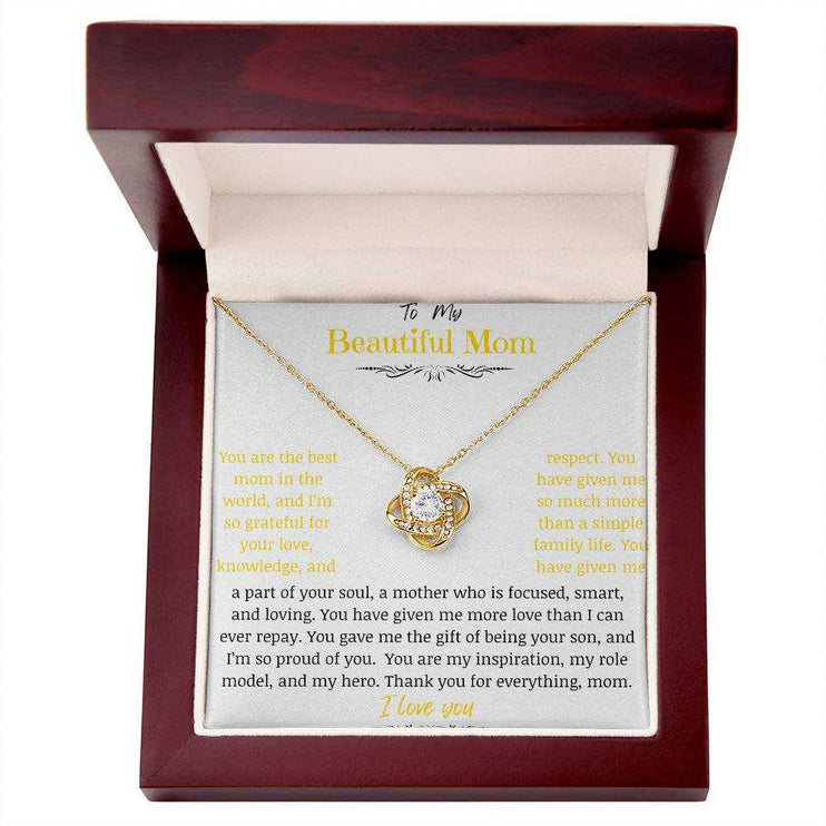 A yellow gold love knot necklace in a mahogany box
