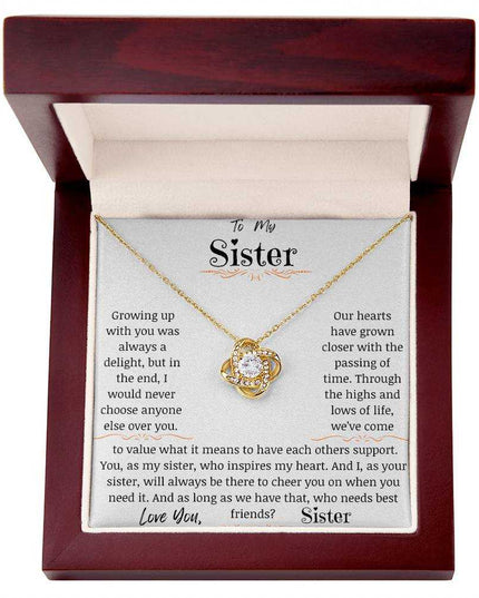 a yellow gold love knot necklace in a mahogany box.